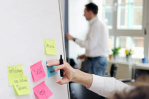 Foto von einem Flip Chart auf dem bunte Post its kleben, welche noch beschrieben werden
