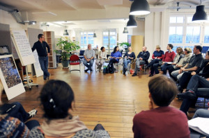 Foto von unserem Büro indem alle Teilnehmer der OE Ausbildung in einem Stuhlkreis sitzen und Vorne ist der Trainer zu sehen