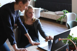 Foto von zwei Frauen, welche auf einen Laptop gucken