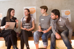 Photo von vier sitzendn Personen, die miteinander diskutieren.